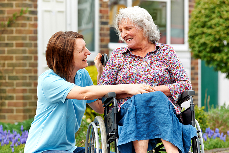 Carer With Senior Woman In Wheelchair